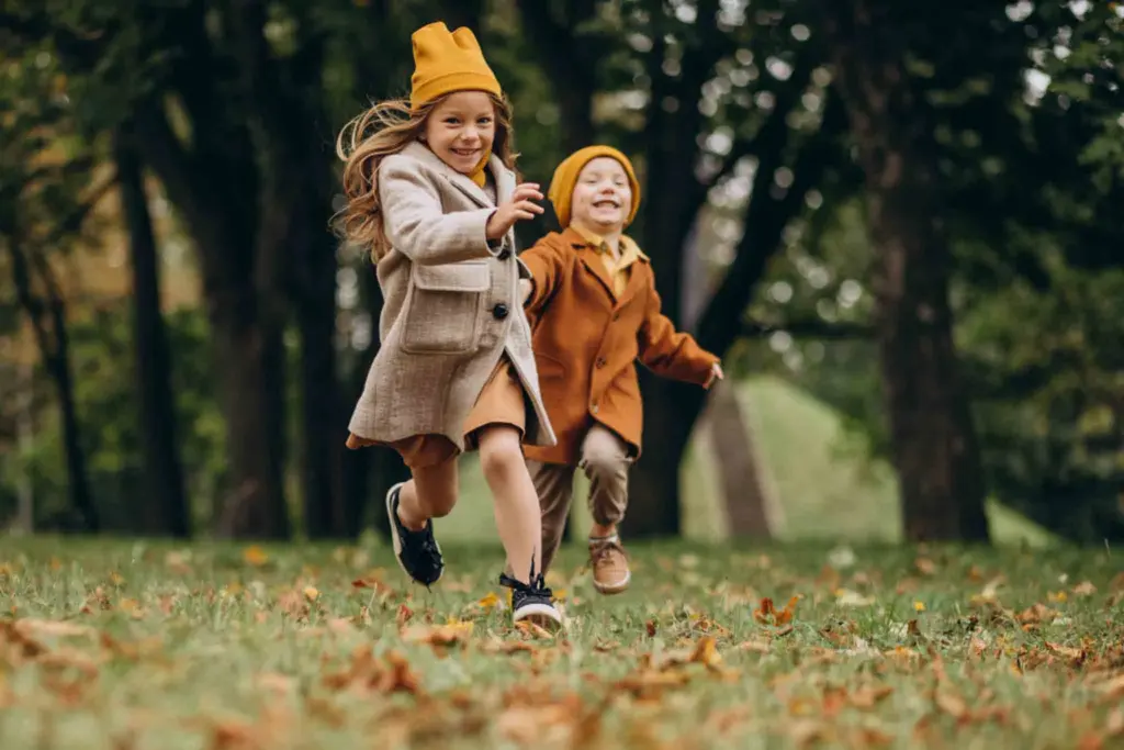 Ñinos jugando en otoño en el parque