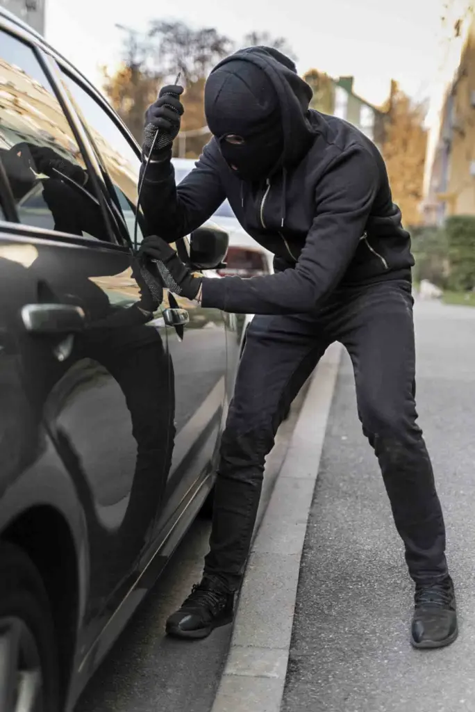 Ladrón intentando abrir un coche