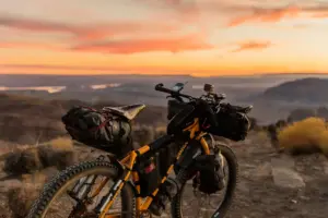 Bicicleta con paisaje montañoso de fondo al atardecer, para mostar los beneficios de utilizar este vehículo y cómo hacerlo con seguridad con un gps